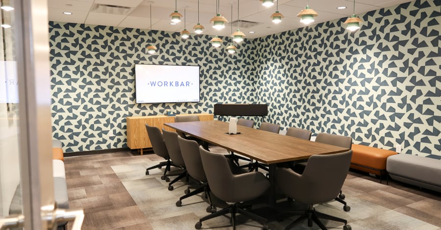 Modern conference room at Workbar Union Square, Somerville, equipped with a long meeting table and a vibrant, patterned accent wall.