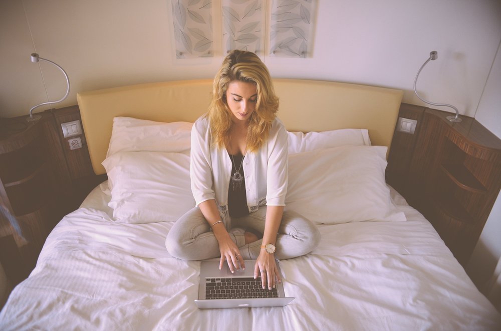 woman working on bed with laptop